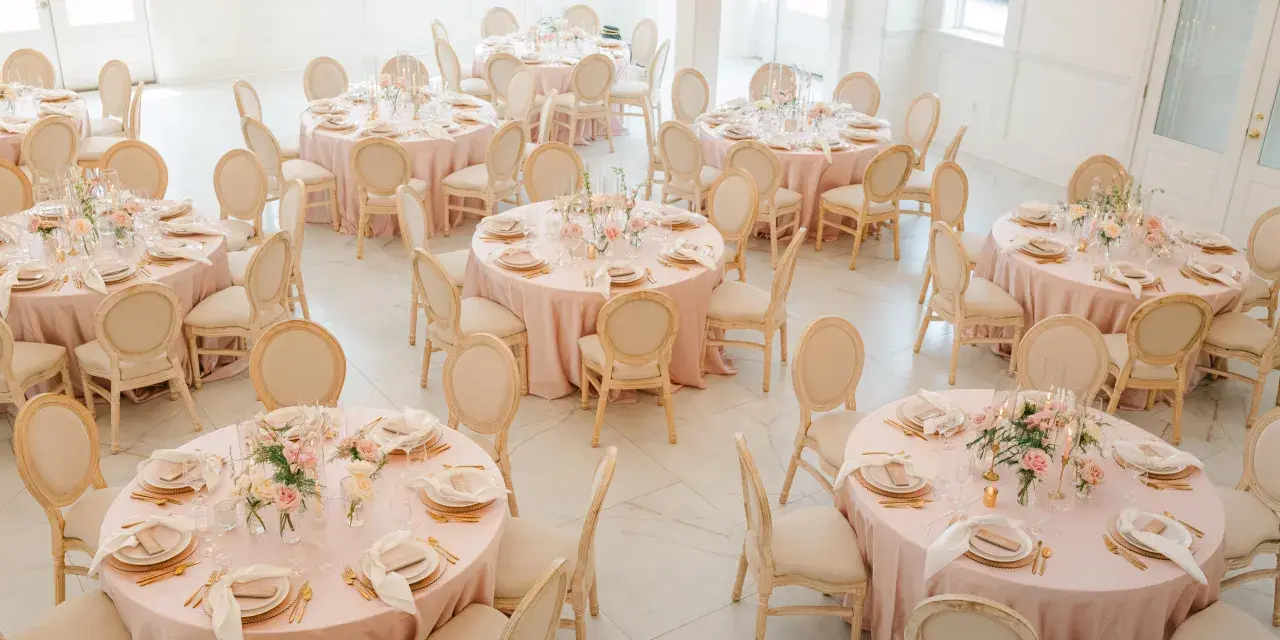 Elegant wedding reception setup inside The Chapel by the Sea with blush linens and floral centerpieces.