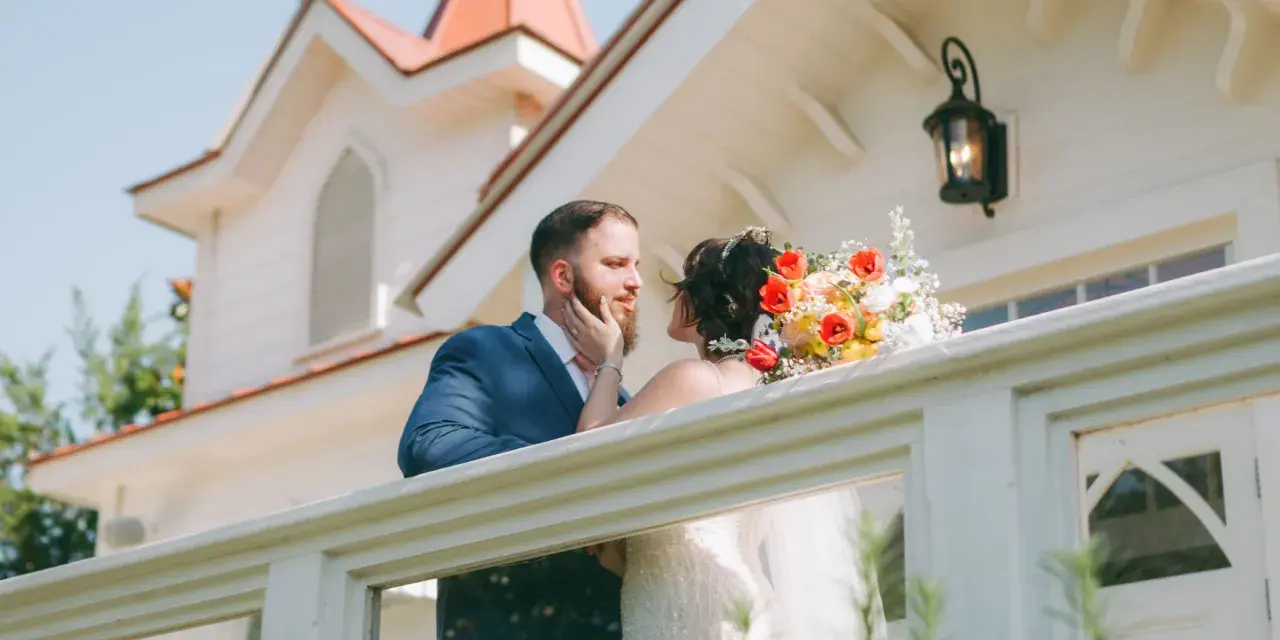 Bride and groom embrace on the porch of The Chapel by the Sea on Tybee Island.