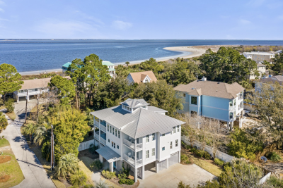 Aerial view of Oceanfront Cottage Rentals’ Tybee Oasis rental home with a view of the ocean, beach and blue sky