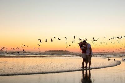 Couple kissing on the beach at sunset