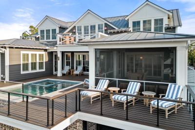 An expansive outdoor back deck with a pool and seating.