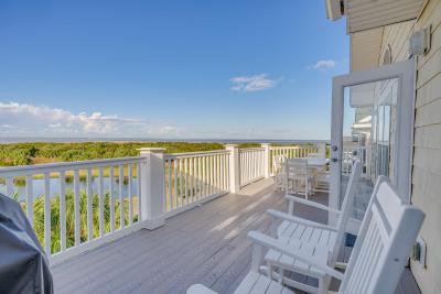 An expansive outdoor balcony overlooking marshland and a dock.