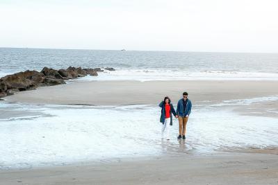 A couple walking the beach on Tybee Island, GA during winter.