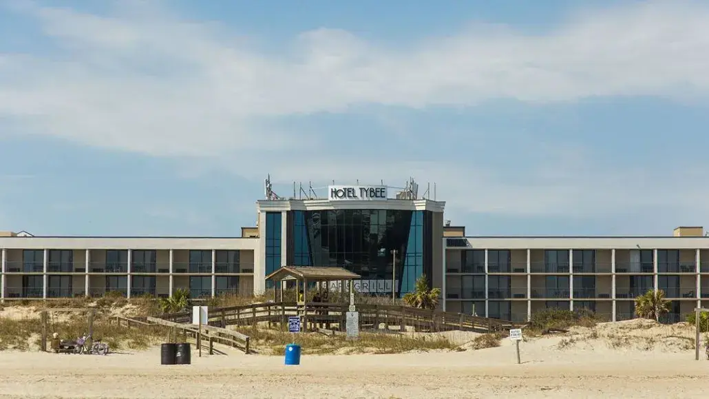 The front exterior view of a hotel on the beach.
