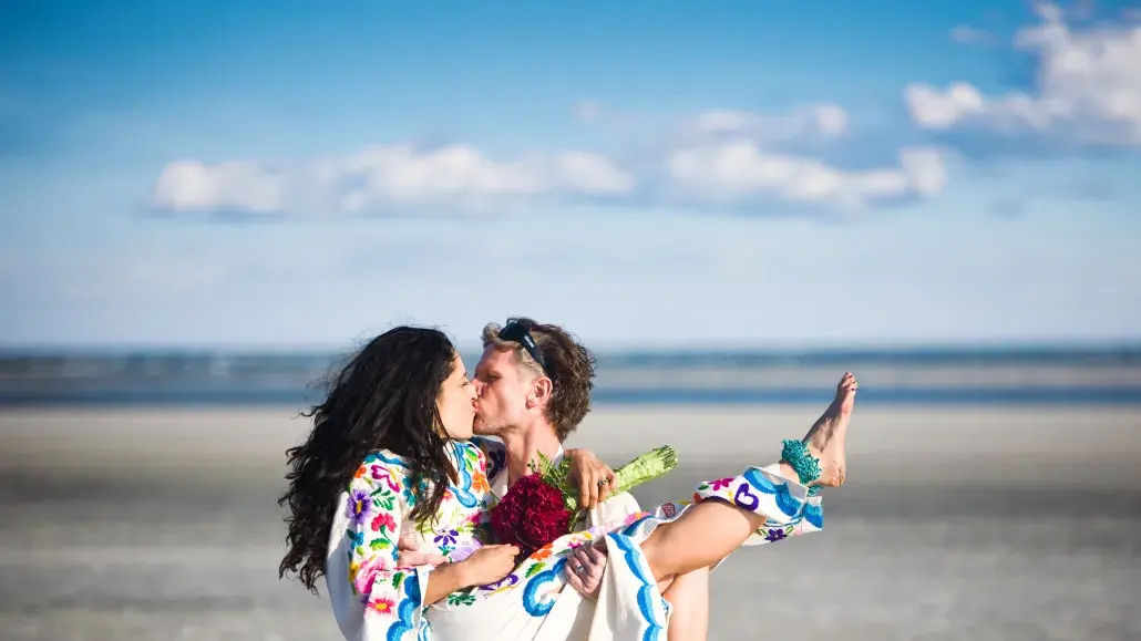 funky beach wedding couple kissing