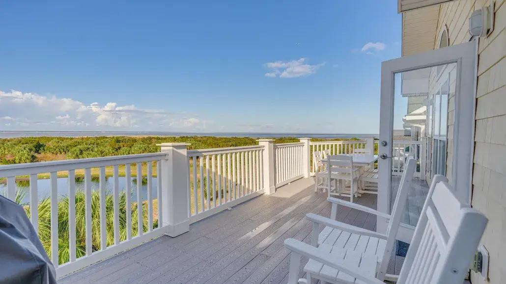 An expansive outdoor balcony overlooking marshland and a dock.