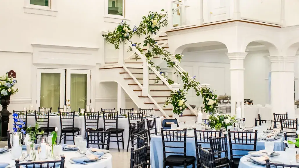 Elegant wedding reception inside The Chapel by the Sea featuring crystal chandeliers and a grand staircase.