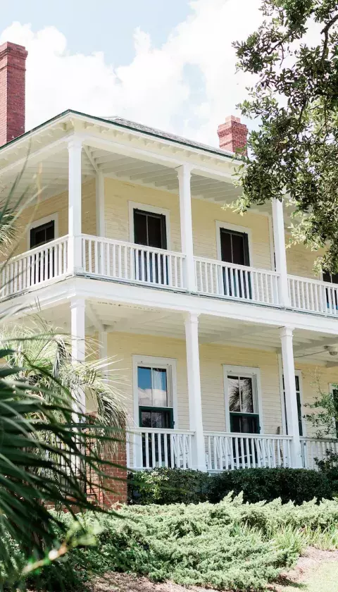 An exterior view of a large beach mansion.