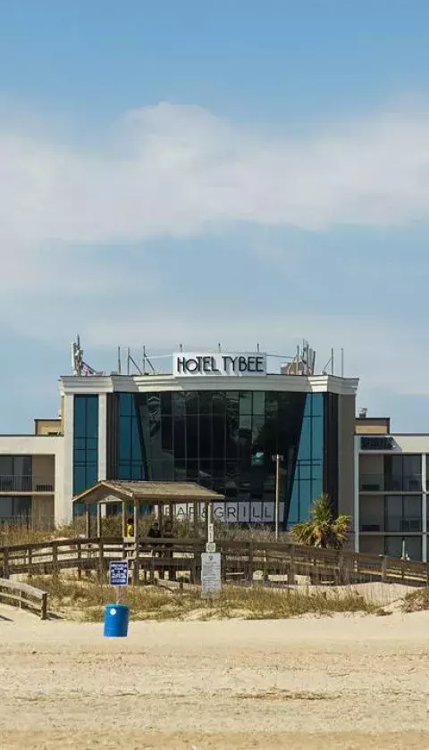 The front exterior view of a hotel on the beach.