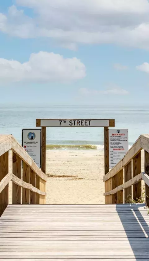 A wooden boardwalk that leads to the beach.