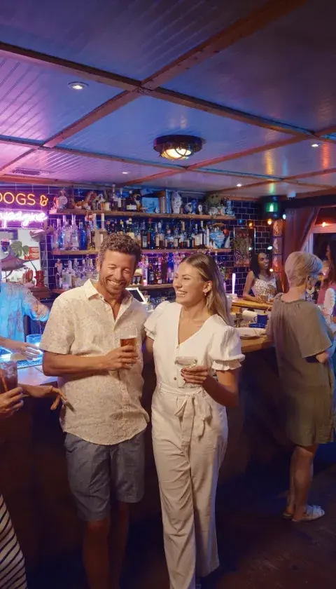 A group of friends laughing and drinking in a restaurant lounge.