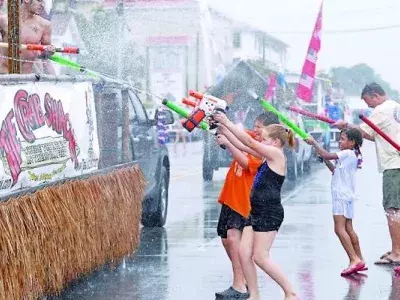 Kids playfully using water guns during the Beach Bum Parade on Tybee Island