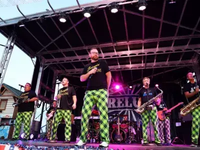 A band playing on stage at an outdoor concert.