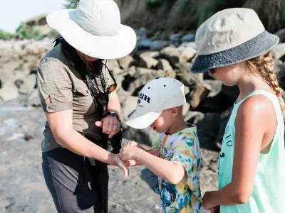 Family exploring the shoreline during a fossil hunting tour with Sundial Charters.