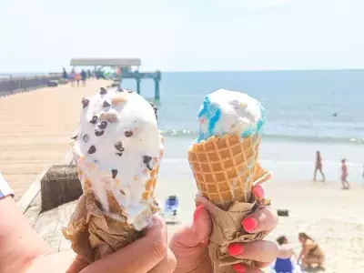 Two ice creams with the beach in the background.