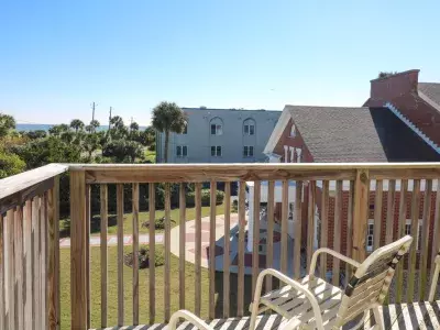 A spacious outdoor deck with seating and partial ocean view.