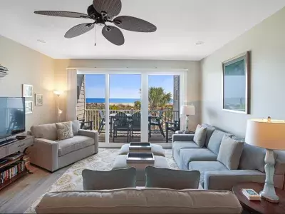 Living area with seating and view of outdoor balcony with oceanview