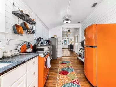 A galley kitchen with orange applicances.