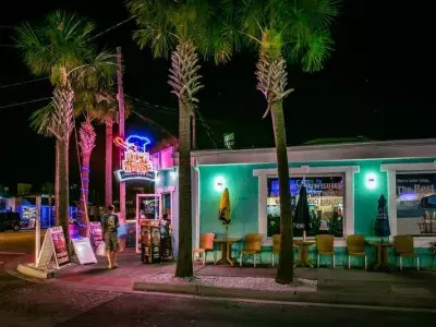 A restaurant and bar at night with neon lights.