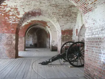 Interior of Fort Pulaski featuring brick walls, wooden floors, and a historic cannon.