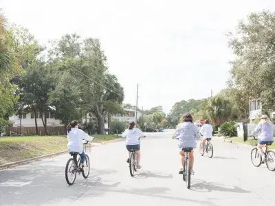 A group of five women riding bikes.