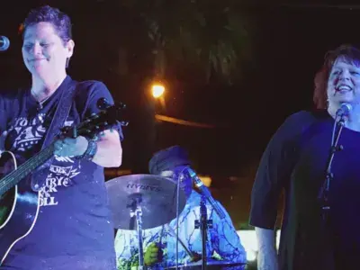 Musicians playing on stage at an outdoor concert.