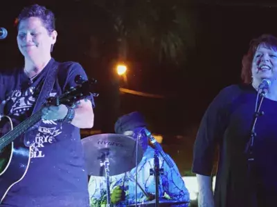 Musicians playing on stage at an outdoor concert.