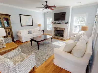 A living room with white seating and a fireplace