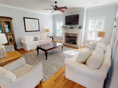 A living room with white seating and a fireplace