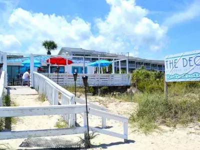 An outdoor walkway to a restaurant surrounded by sand.