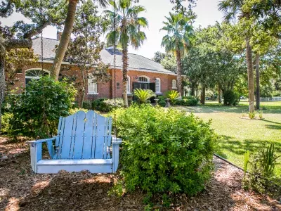 A blue backyard swing hanging from a tree.