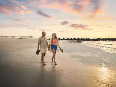 couple walking at sunrise along south beach