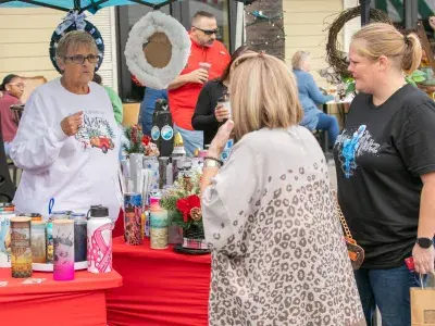 Tybee Holiday Market vendor and customers standing at a booth outdoors