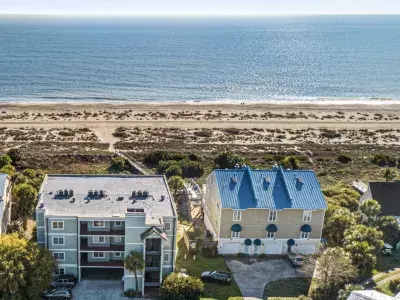 Aerial view of Oceanfront Cottage Rentals’ Ocean Queen 4-story home with an oceanfront view on a sunny day with blue skies.