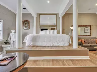 A Greek Mythology themed hotel suite with a large bed and white bedding.