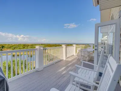 An expansive outdoor balcony overlooking marshland and a dock.