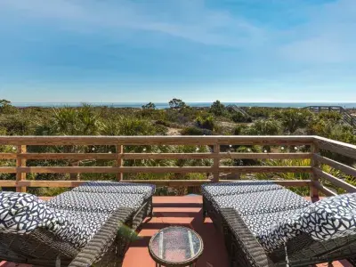 An oceanfront balcony home with comfortable lounge chairs.