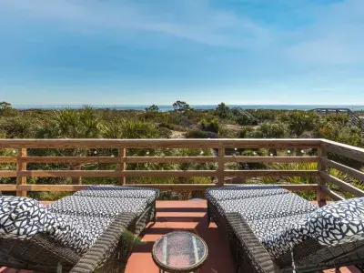 An oceanfront balcony home with comfortable lounge chairs.