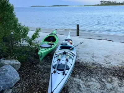 Kayak boats sitting on the sand facing the ocean on Tybee Island, GA.