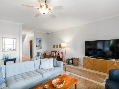 Bright and cozy living room at Sunset Hammock vacation rental on Tybee Island, featuring a large flat-screen TV, modern furnishings, and coastal-inspired décor.