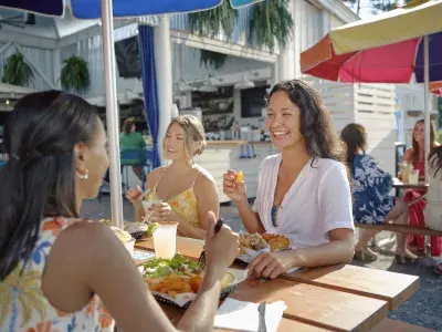 A group of friends enjoying a restaurant meal in an outdoor setting.