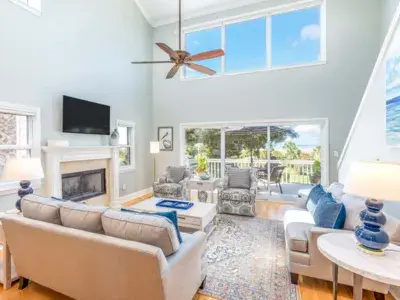 Oceanfront living room at A Salty Senorita with large windows, sliding glass doors and views of the water and outdoor deck.