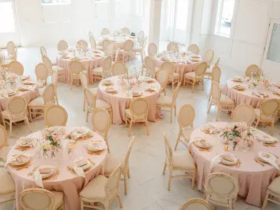 Elegant wedding reception setup inside The Chapel by the Sea with blush linens and floral centerpieces.