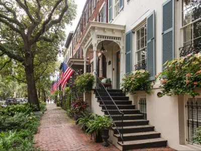 Historic homes with colorful shutters and lush greenery line Savannah's iconic Jones Street.