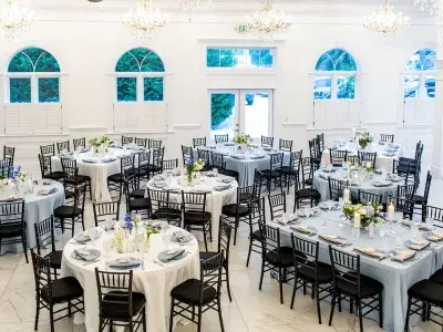 Wedding reception inside The Chapel by the Sea with elegant tables, chandeliers and arched windows.