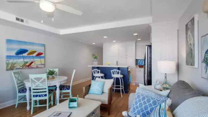 An open floorplan including a living, dining and kitchen with coastal decor.