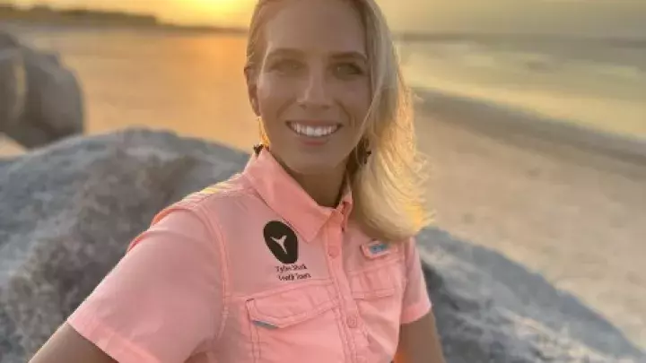 Headshot of Miss K with Tybee Shark Teeth Tours wearing a pink shirt at sunset on the beach