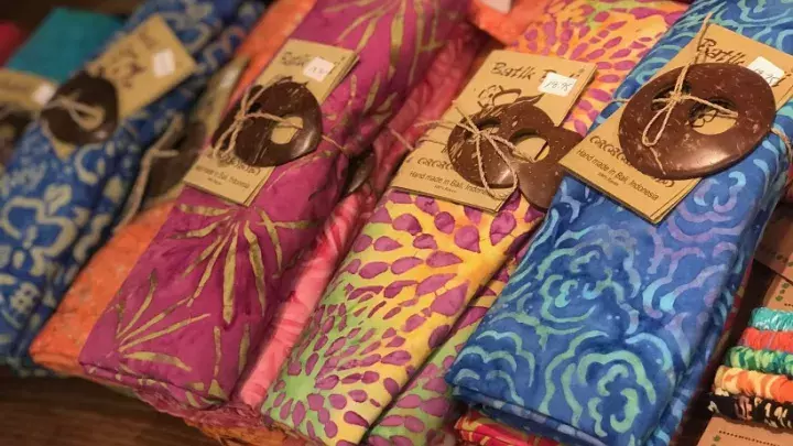 A display of colorful beach sarongs on a table