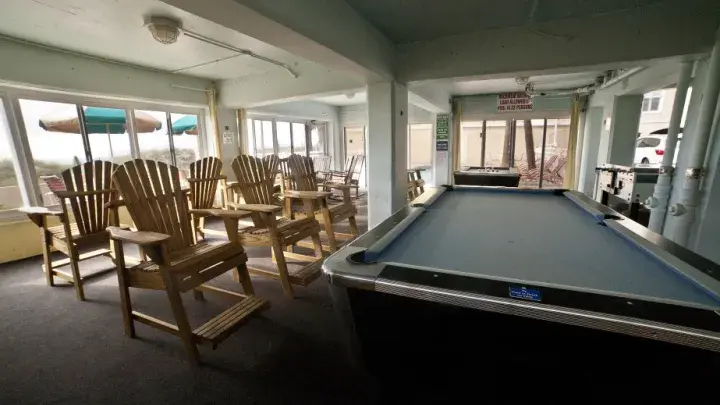 A large game room with two skee ball tables and seating.