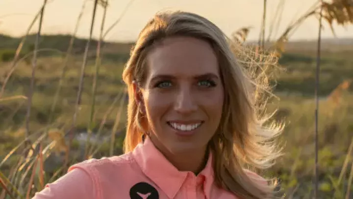 Headshot of Miss K with Tybee Shark Teeth Tours wearing a pink shirt with the beach in the background.